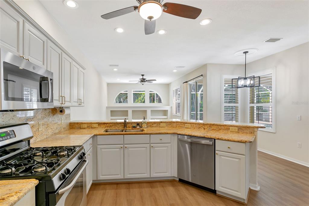 11209 Pine Lilly Place Lakewood Ranch, FL 34202 - Photo 10 of 26 a kitchen with stainless steel appliances granite countertop a sink stove and cabinets