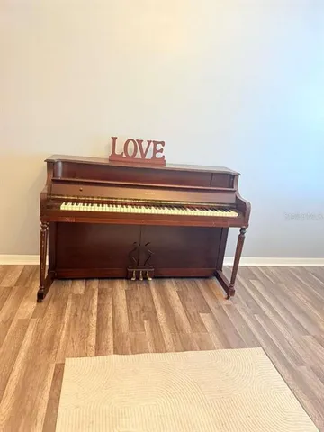 a living room with furniture a flat screen tv and next to a window