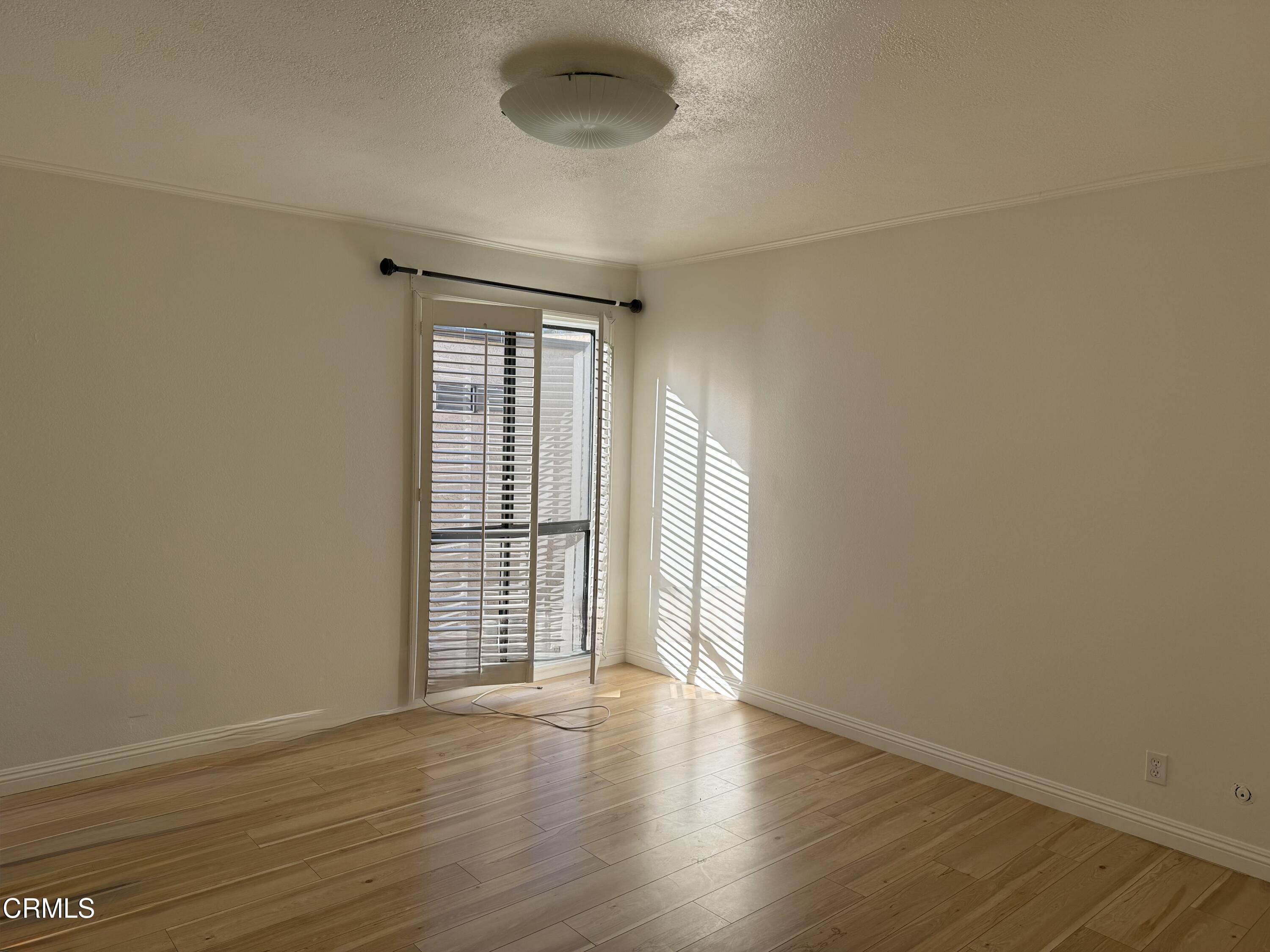108 North Chapel Avenue, Unit 5 Alhambra, CA 91801 - Photo 14 of 30 a view of an empty room with wooden floor and a window