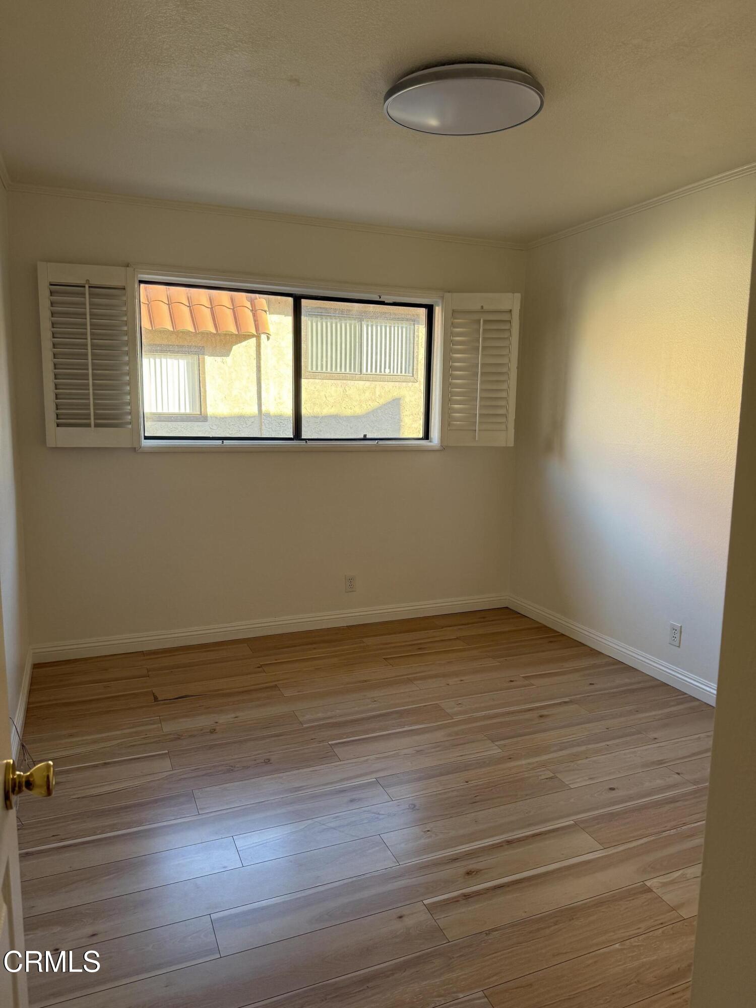 108 North Chapel Avenue, Unit 5 Alhambra, CA 91801 - Photo 20 of 30 a view of an empty room with wooden floor and a window