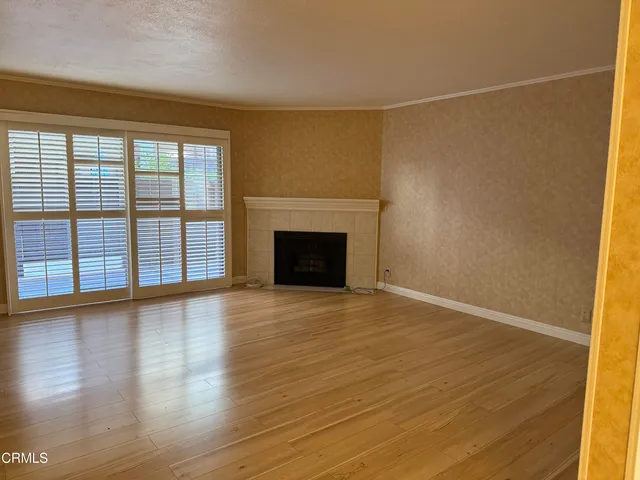 a view of a livingroom with wooden floor and a fireplace