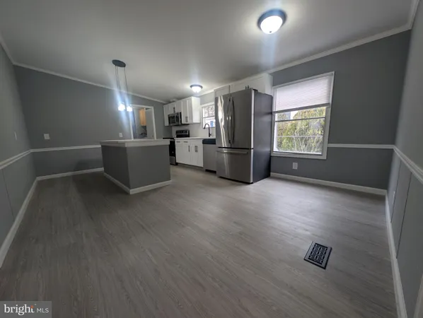 a kitchen with stainless steel appliances wooden floor and window