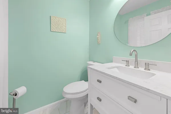 a bathroom with a toilet sink vanity and mirror
