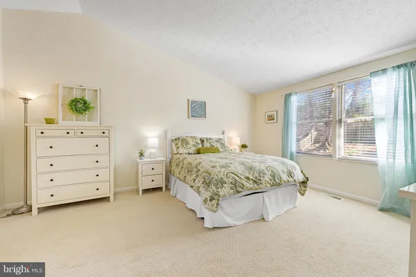 a spacious bedroom with a bed and a window