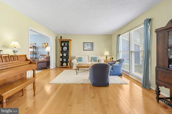 a living room with furniture a flat screen tv and a refrigerator