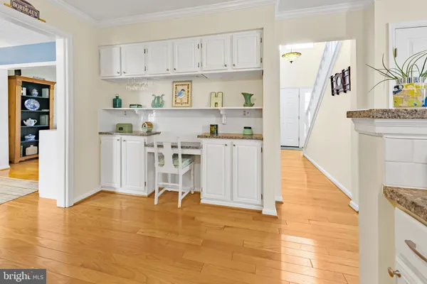 a kitchen with stainless steel appliances granite countertop a refrigerator a stove and white cabinets with wooden floor