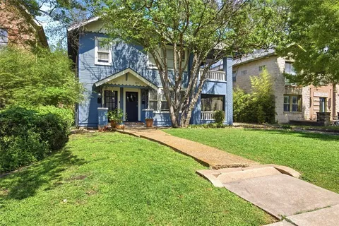 a front view of a house with yard and green space