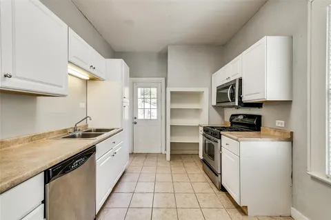 a kitchen with a sink stove top oven and cabinets