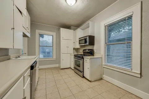a kitchen with a sink cabinets and window