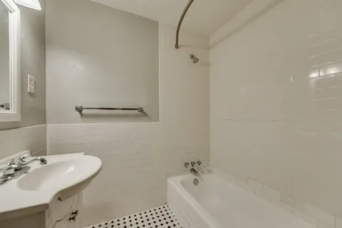 a bathroom with a sink a tub and a mirror