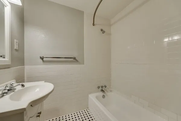 a bathroom with a sink a tub and a mirror