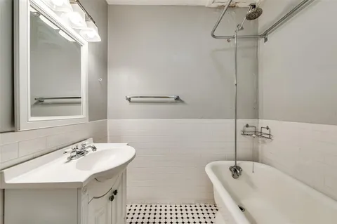 a bathroom with a tub sink and mirror
