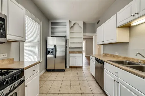 a kitchen with a stove a refrigerator and cabinets