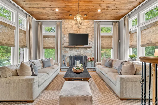 a living room with furniture fireplace and large windows