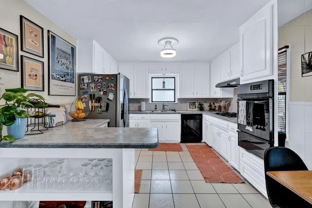 a living room with furniture kitchen view and a window