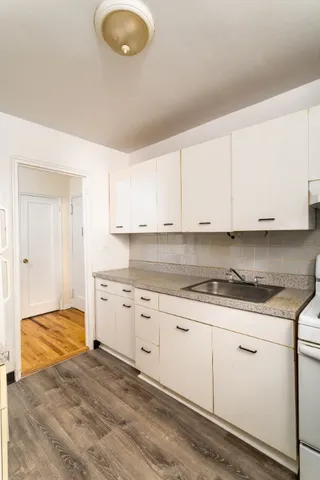 a kitchen with granite countertop a sink a stove and cabinets