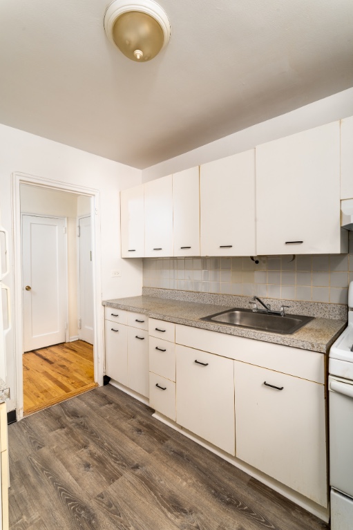 5610 Netherland Avenue, Unit 1G Bronx, NY 10471 - Photo 11 of 17 a kitchen with granite countertop a sink a stove and cabinets