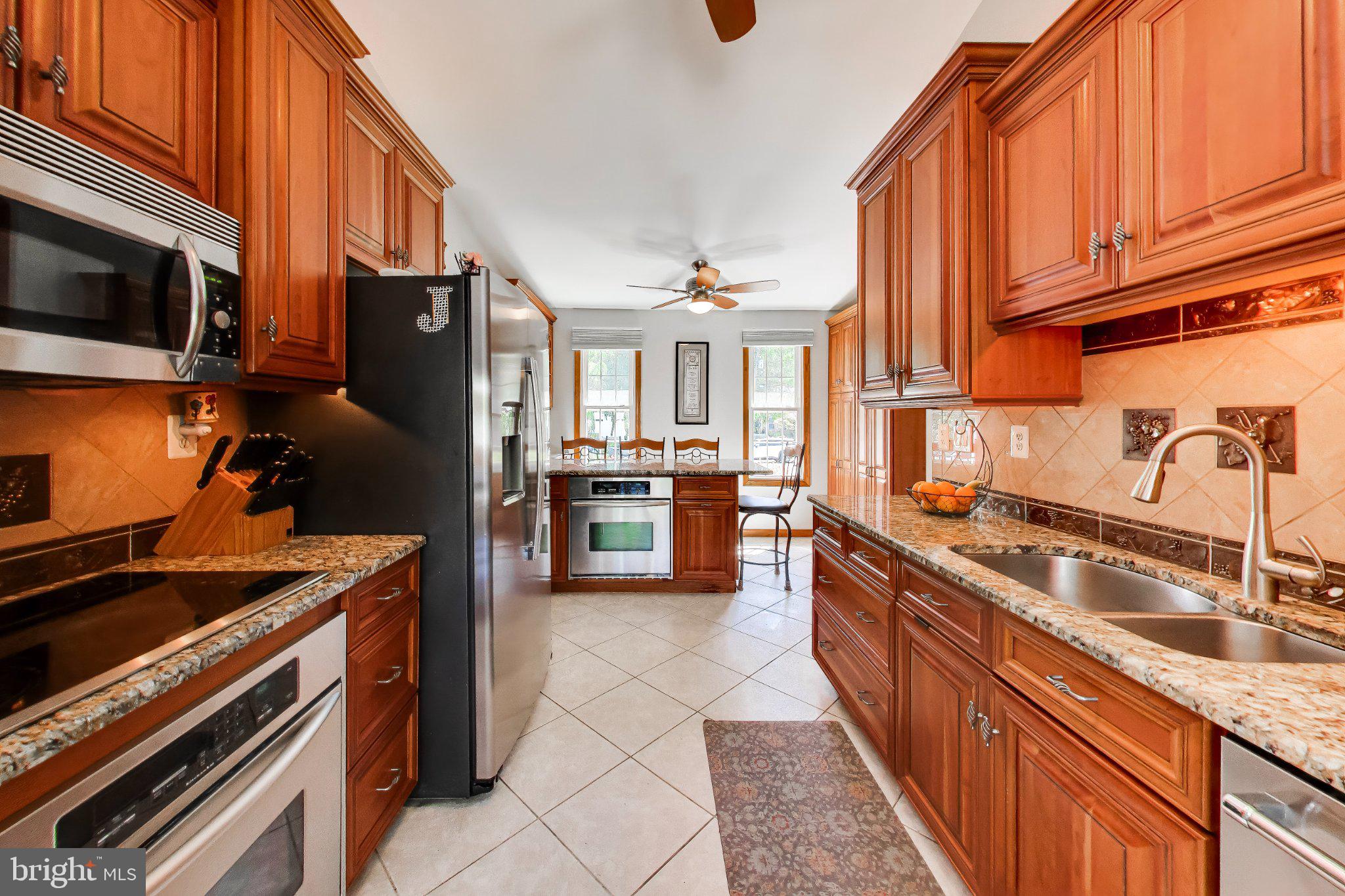 14216 Alderton Road Silver Spring, MD 20906 - Photo 8 of 63 a kitchen with stainless steel appliances granite countertop a stove a sink and a microwave