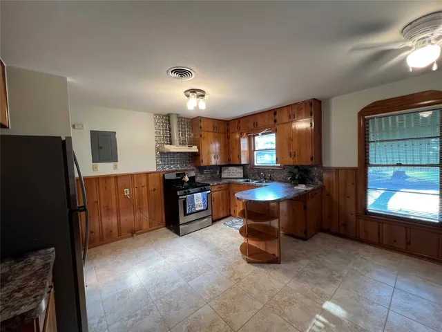 a kitchen with stainless steel appliances a refrigerator a sink a stove a microwave and wooden cabinets