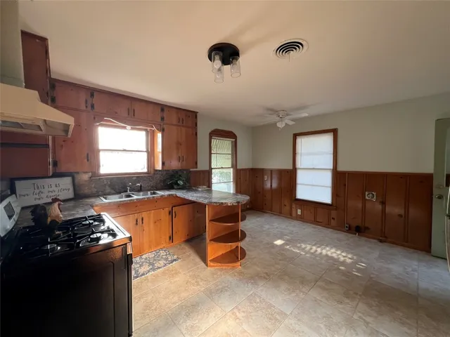 a large kitchen with stainless steel appliances granite countertop a stove and a refrigerator