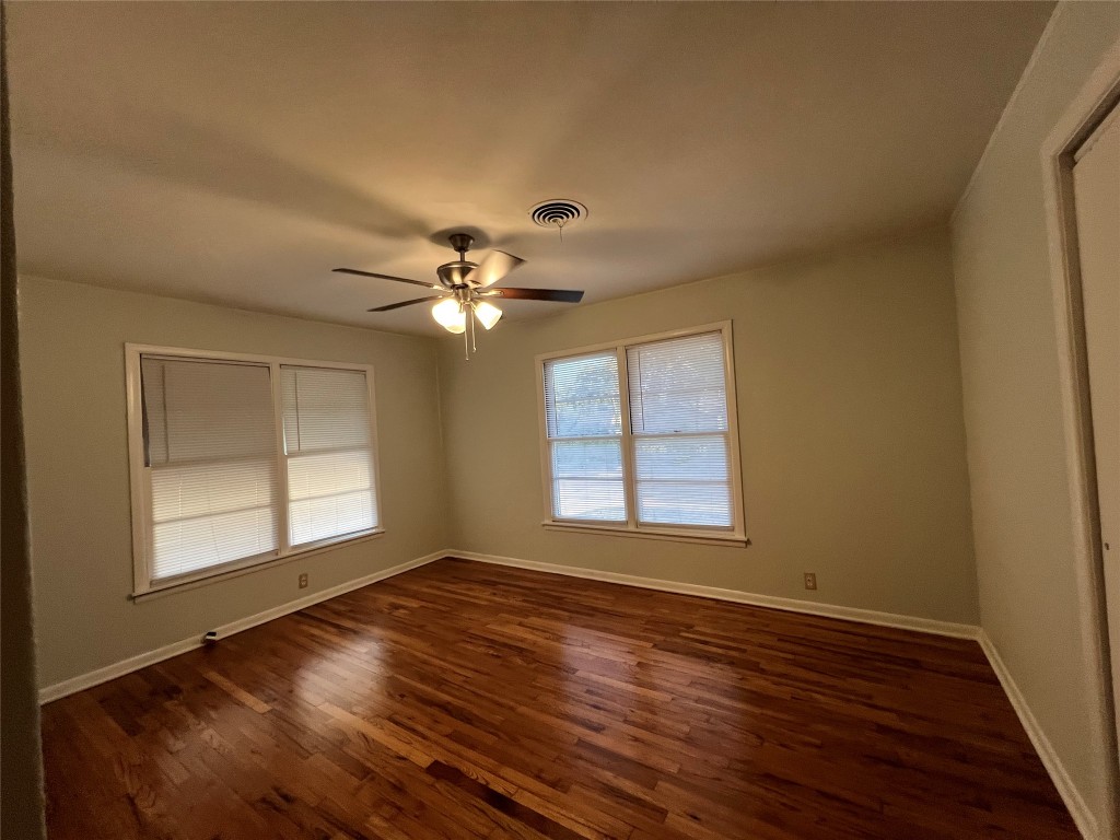 606 West 11th Street Taylor, TX 76574 - Photo 7 of 9 a view of an empty room with wooden floor and a window