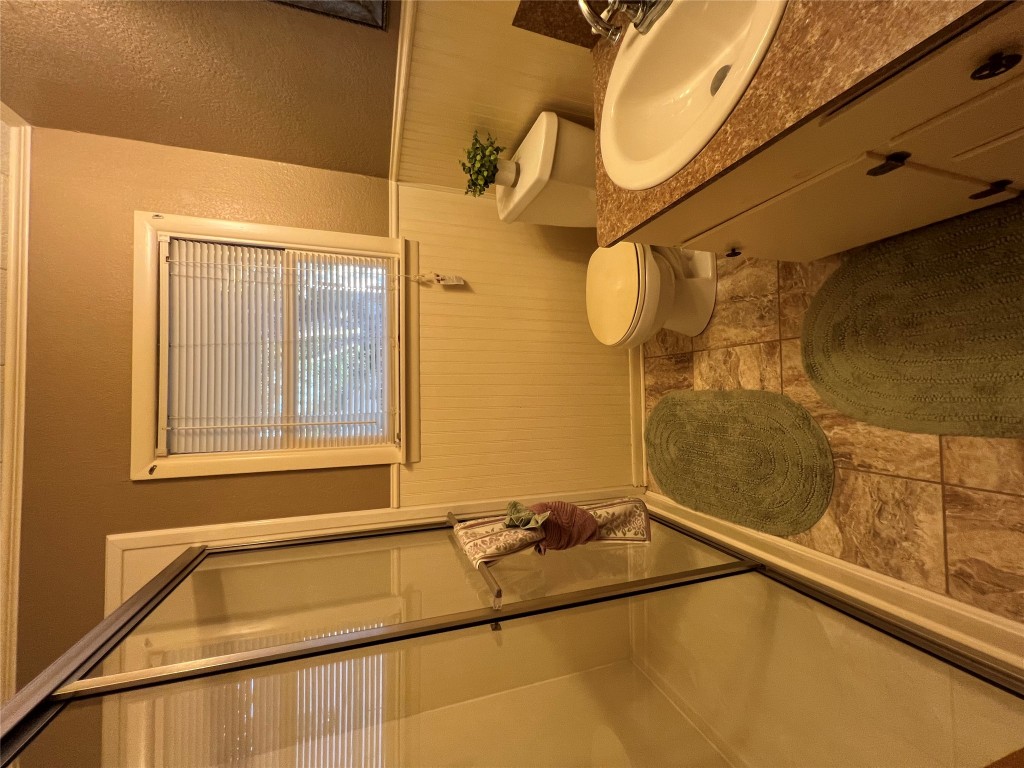 606 West 11th Street Taylor, TX 76574 - Photo 9 of 9 a bathroom with a granite countertop sink toilet and a mirror