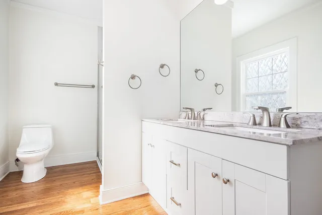 a bathroom with a granite countertop sink a toilet and a mirror