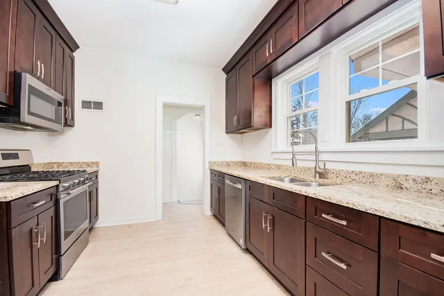 a kitchen with stainless steel appliances granite countertop a sink stove and refrigerator