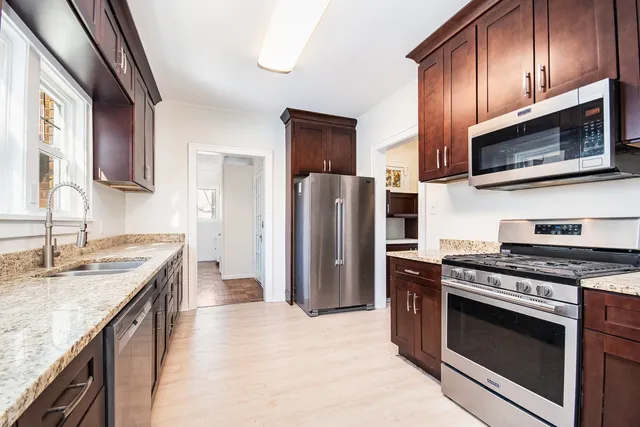 a kitchen with stainless steel appliances granite countertop a stove microwave refrigerator and sink