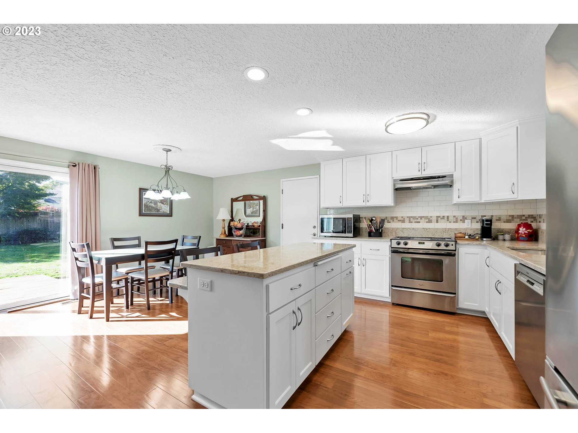 576 67th Street Springfield, OR 97478 - Photo 3 of 32 a kitchen with white cabinets and stainless steel appliances