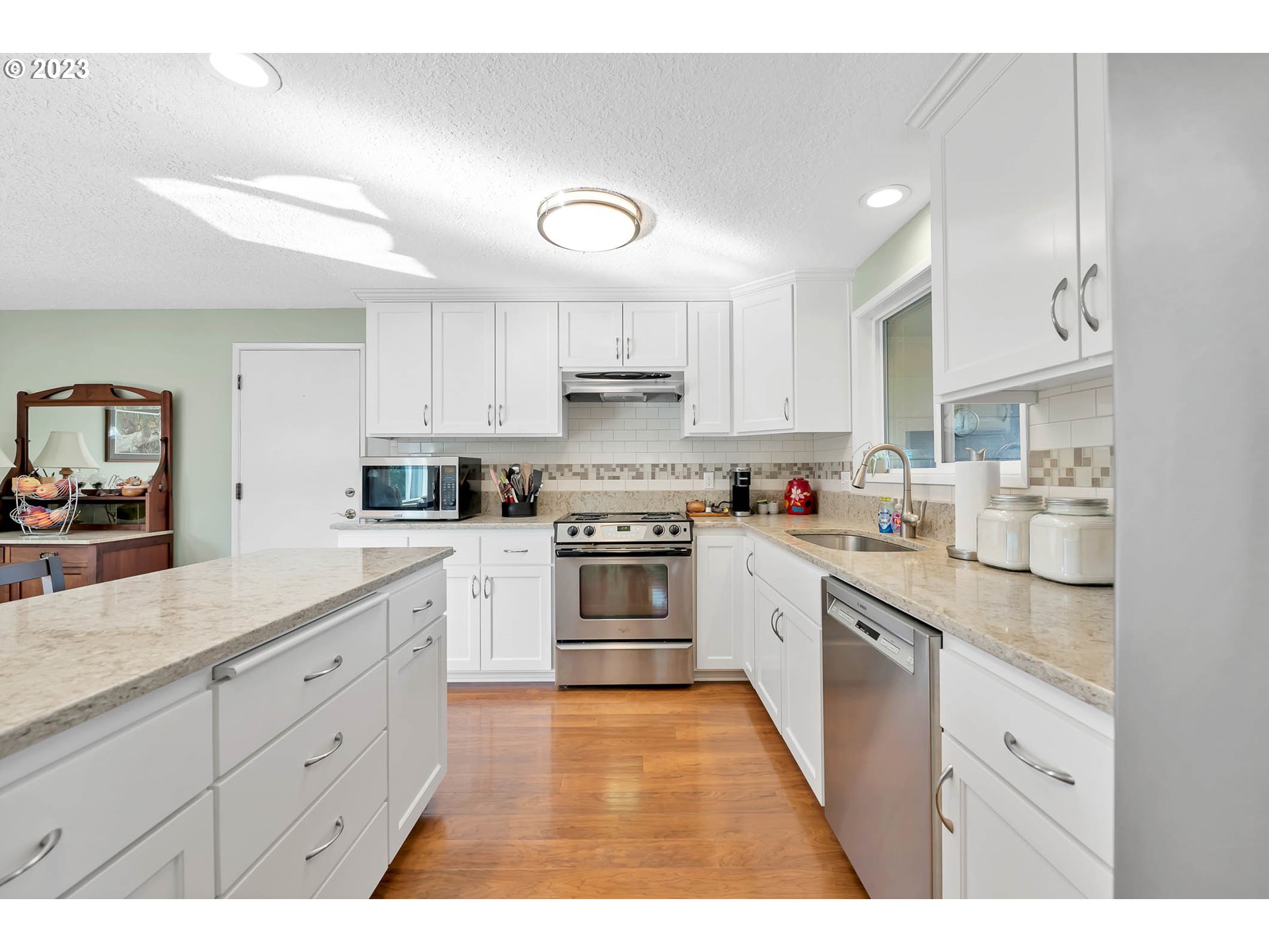 576 67th Street Springfield, OR 97478 - Photo 4 of 32 a kitchen with granite countertop white cabinets and stainless steel appliances