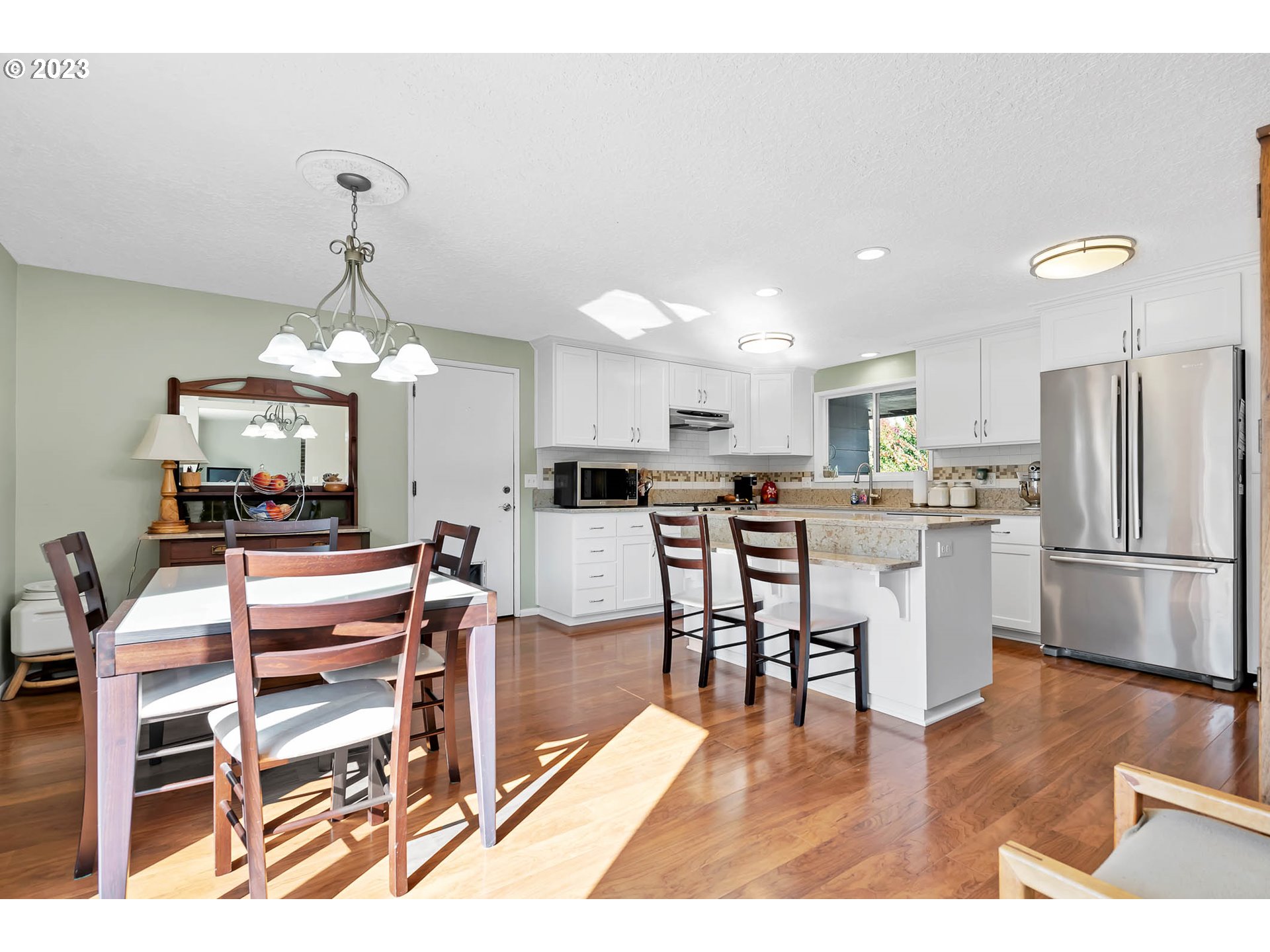 576 67th Street Springfield, OR 97478 - Photo 5 of 32 a view of a dining room and livingroom with furniture wooden floor a chandelier