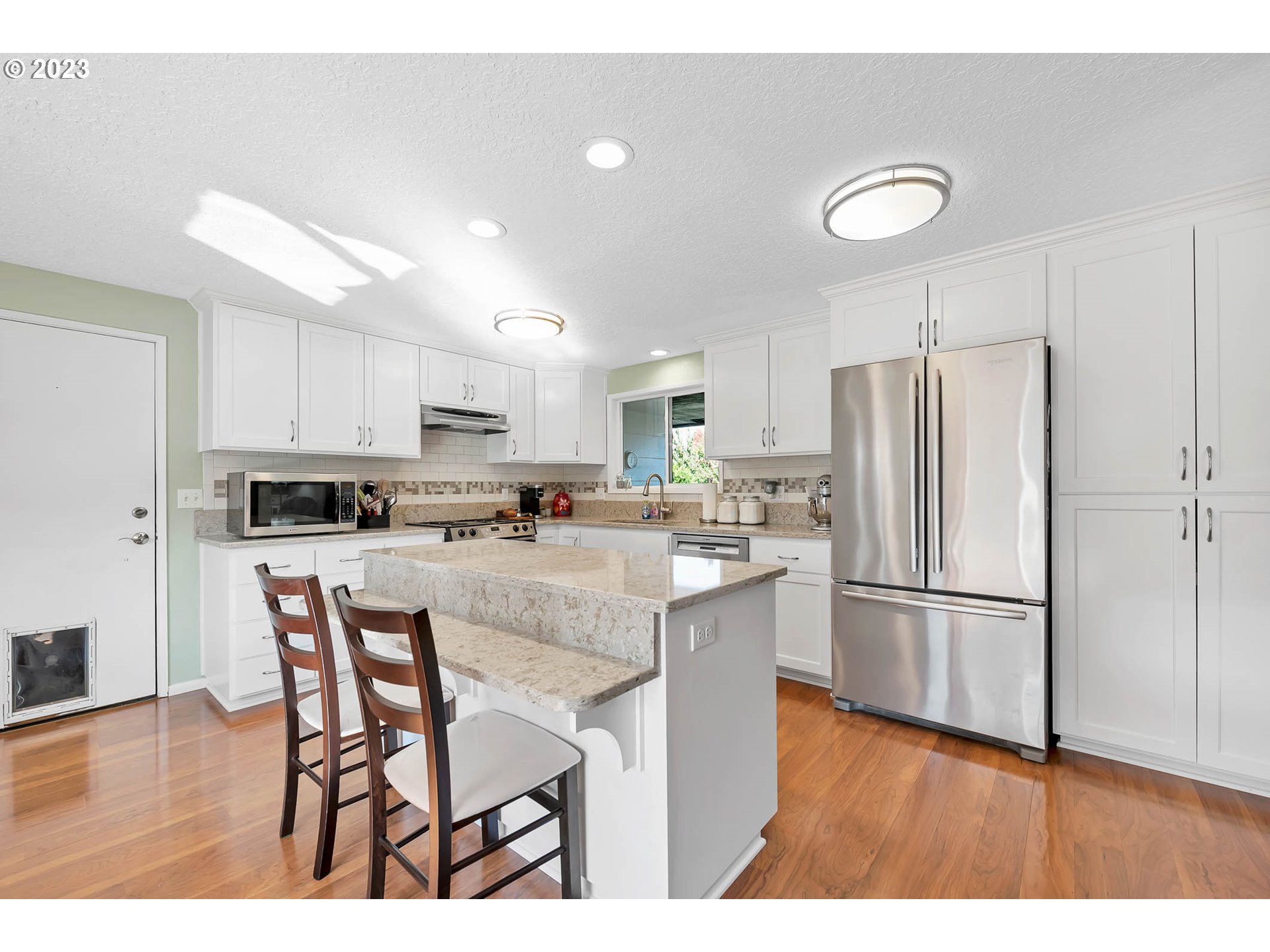 576 67th Street Springfield, OR 97478 - Photo 6 of 32 a kitchen with stainless steel appliances granite countertop a refrigerator a stove a sink dishwasher and a refrigerator with wooden floor