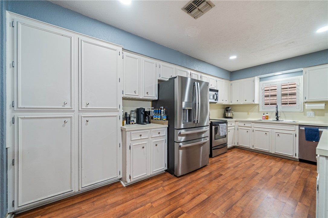 2217 Post Oak Drive Portland, TX 78374 - Photo 10 of 39 a kitchen with white cabinets and stainless steel appliances