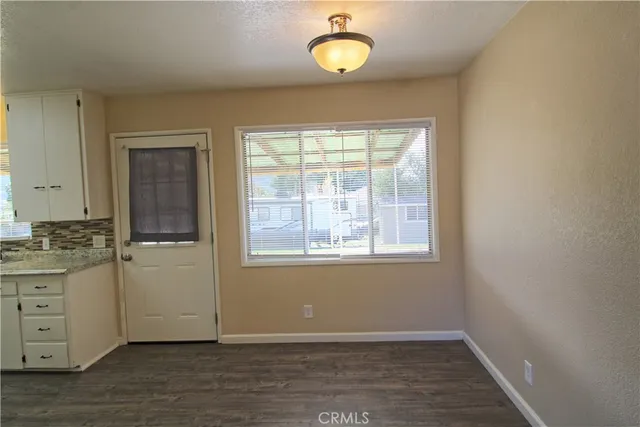 an empty room with a window and wooden floor