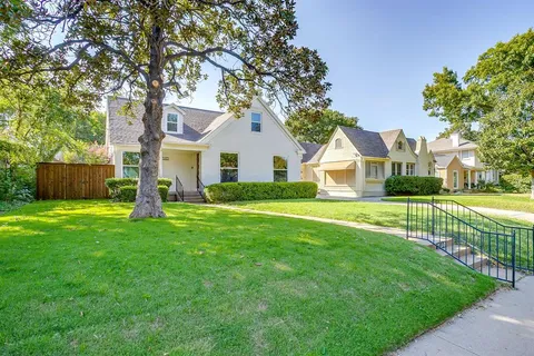 a front view of a house with a yard and green space
