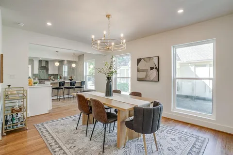 a dining room with furniture a chandelier and wooden floor