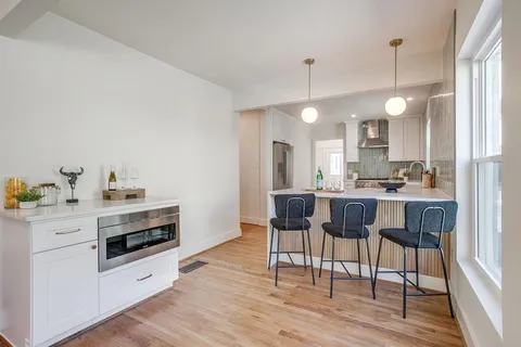 a kitchen with cabinets and chairs