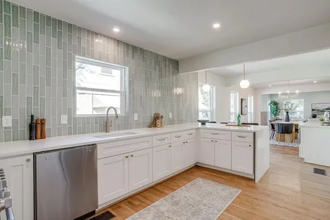 a large white kitchen with lots of counter space and a sink