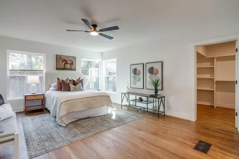 a bedroom with a bed and wooden floor