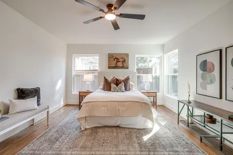 a spacious bedroom with a bed a couch and dresser