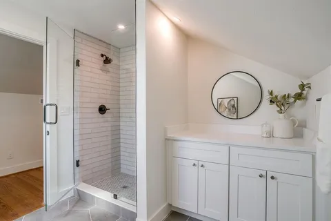 a bathroom with a shower a mirror and a sink