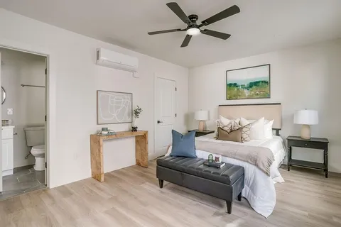 a spacious bedroom with a bed and a chandelier