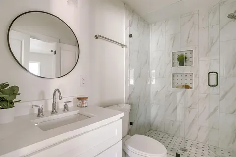 a bathroom with a sink a toilet and a mirror