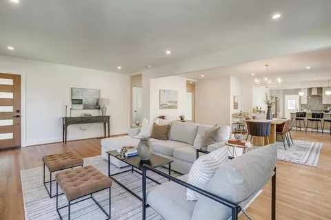a living room with furniture and a view of kitchen