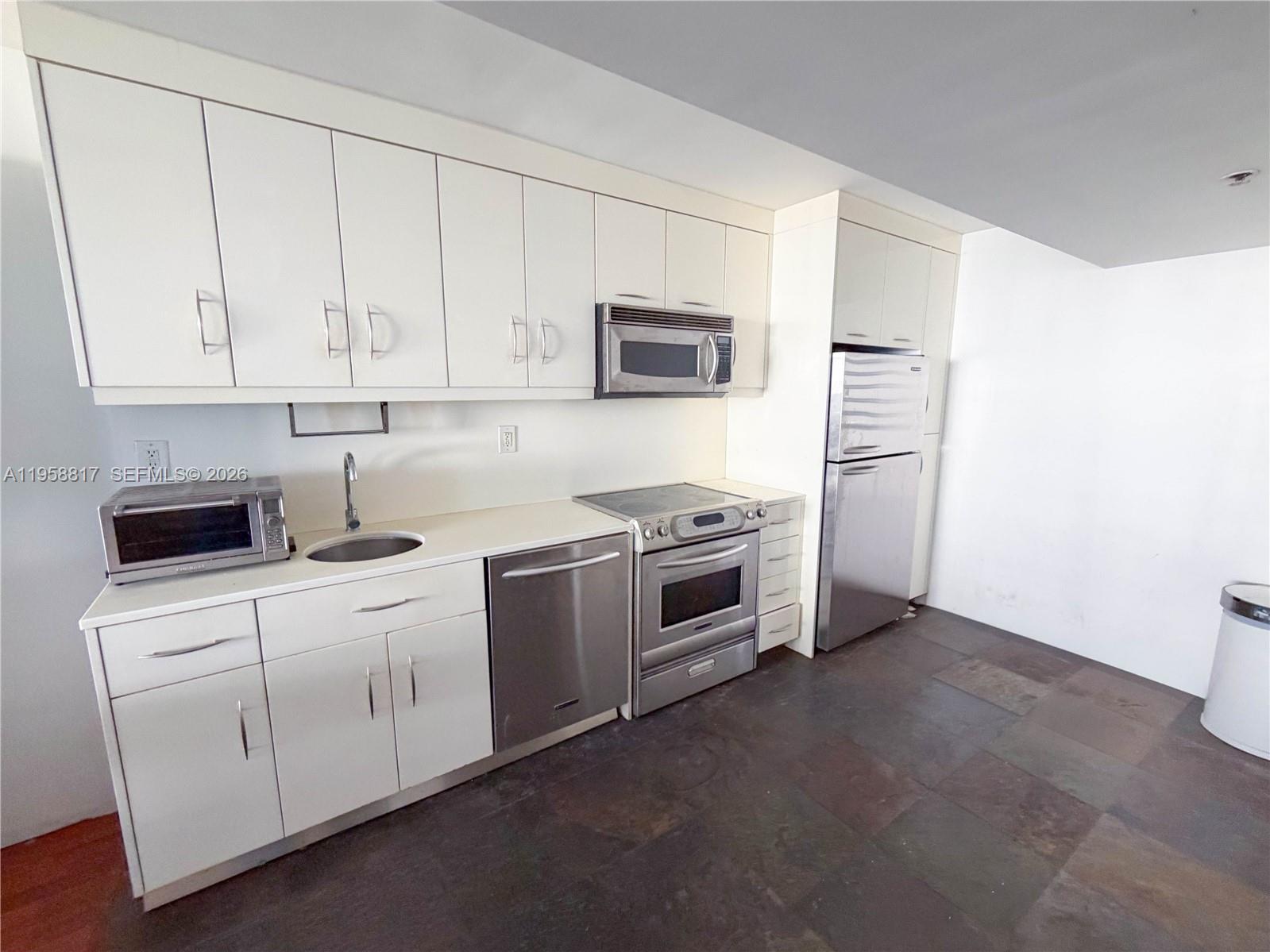 555 Northeast 15th Street, Unit PHF Miami, FL 33132 - Photo 9 of 17 a kitchen with stainless steel appliances white cabinets and a sink
