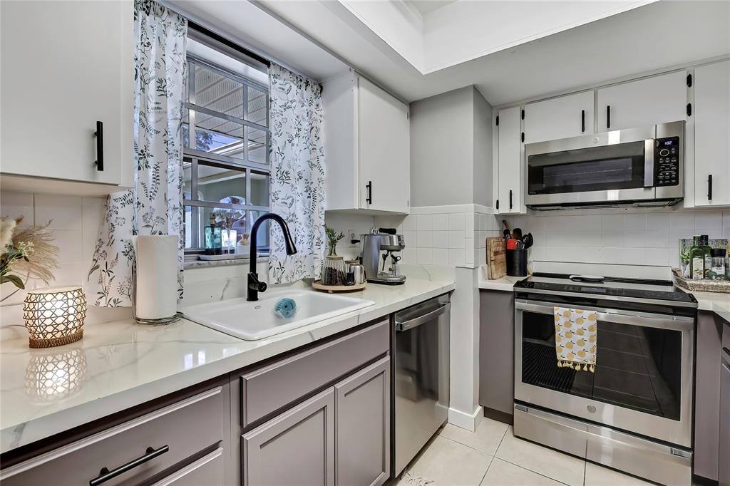 368 Portland Avenue Spring Hill, FL 34606 - Photo 19 of 38 a kitchen with stainless steel appliances a stove microwave and sink