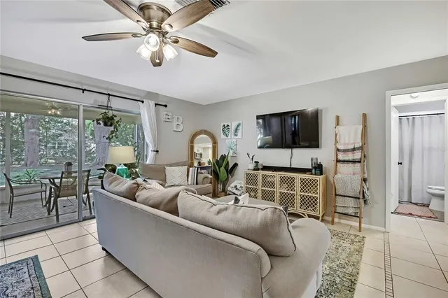 a living room with furniture a flat screen tv and a large window