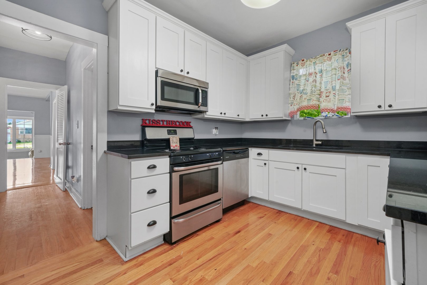 5648 Hawthorne Avenue Berkeley, IL 60163 - Photo 10 of 25 a kitchen with stainless steel appliances granite countertop white cabinets a sink and dishwasher with wooden floor