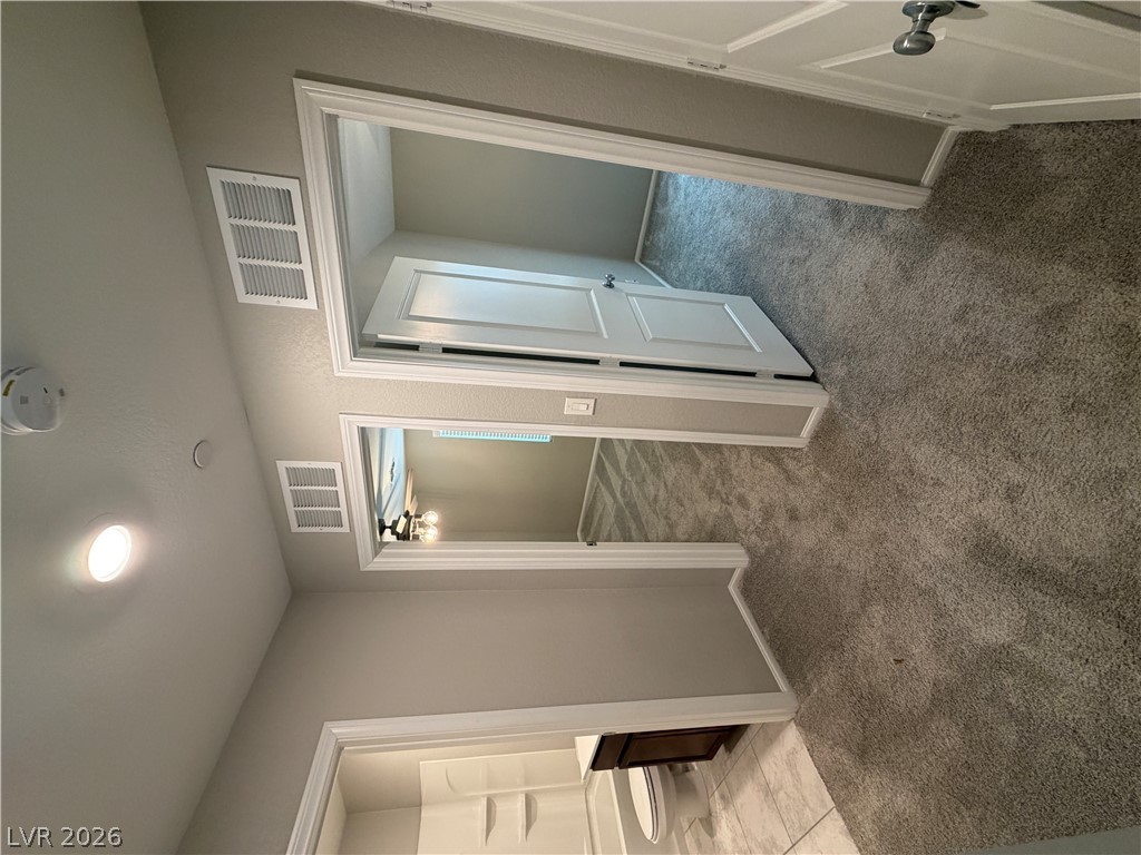 916 Riggs Flats Avenue North Las Vegas, NV 89086 - Photo 25 of 43 A hallway connects carpeted rooms to a tiled bathroom accented with modern trim work.